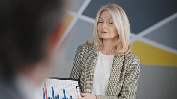 Beautiful Lady Financial Director Making Presentation Speech for Colleagues Showing Graph to