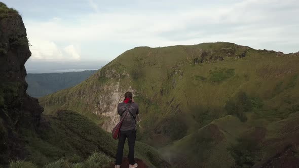 Photographer Traveler Photographs the Landscape on the Edge of the Mountain