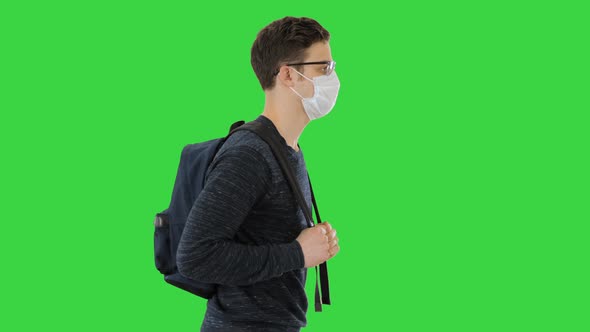 Student in Protective Masks Walking with Backpack on a Green Screen, Chroma Key.