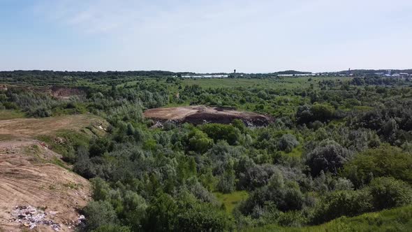 Aerial drone view of a flying over the technogenic landscape among rural agricultural fields.