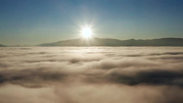Picturesque mountain landscape with a sea of thick clouds and fog at sunrise.
