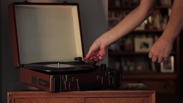 Woman playing Records on Vintage Record Player.
