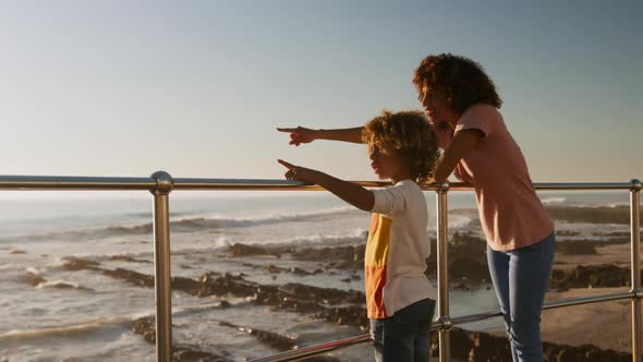 Mother and son pointing away the sea