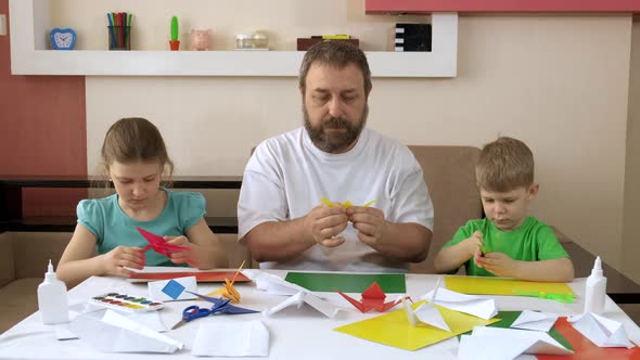 Dad and Children Make Paper Cranes in the Apartment.. Social Distancing and Self-isolation in