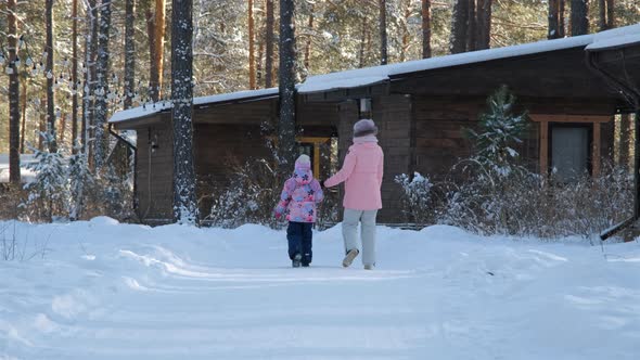 Little Girl with Mom Walking in Frosty Winter Day