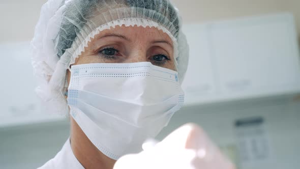 Female Dentist in a Face Mask and a Medical Cap