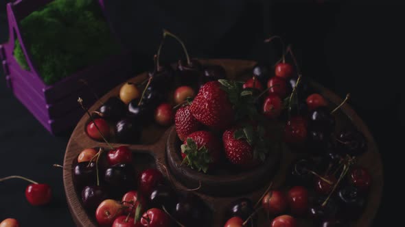 Menazhnitsa with Red Strawberries and Cherries on a Dark Background