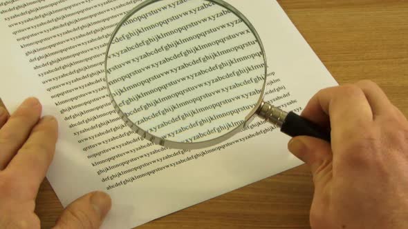 Looking trough Magnifying Glass at small print in contract