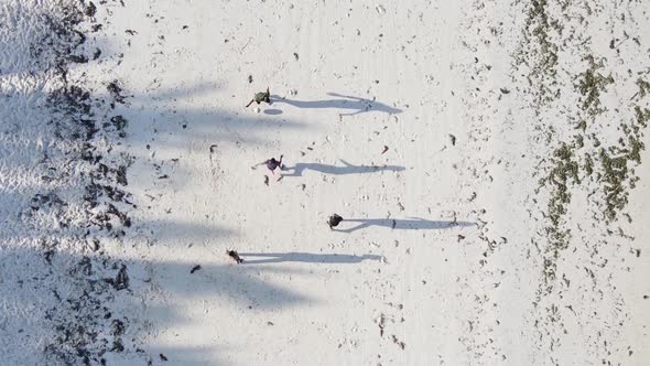 Vertical Video People Play Football on the Beach in Zanzibar Tanzania Aerial View