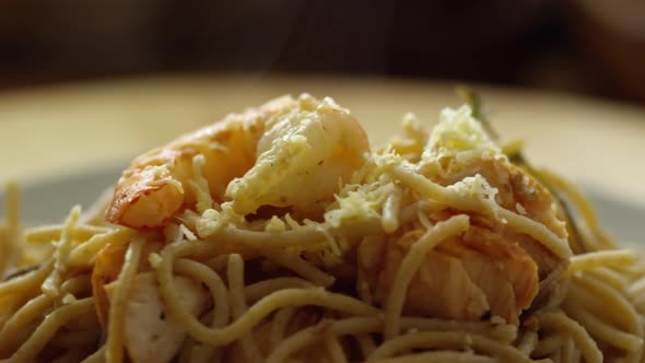 Sprinkling Cheese on Shrimp Pasta