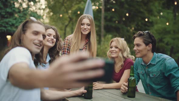 Group Of Friends Drinking Beer And Taking Photos On Phone