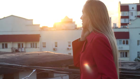 Woman On A Rooftop Talking On The Phone At Sunset