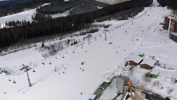 Aerial Ski Slopes with Skiers and Ski Lifts on Ski Resort in Snowy Mountains