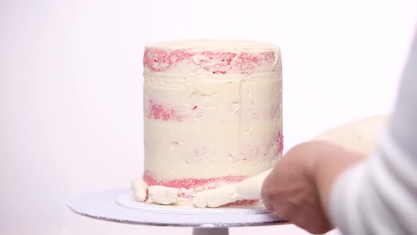 Time lapse. Step by step. Icing tall birthday cake with white buttercream icing.