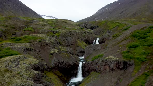 Waterfalls flowing and stacked in Iceland with drone video moving in and up.