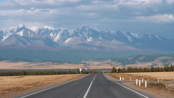 Motion On Road Going To Mountain Summits With Glaciers Through Desert Prairie