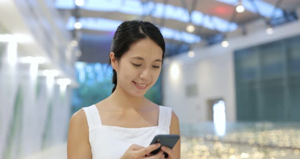 Woman look at mobile phone inside shopping center