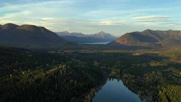 Lush Forest Scenery and Magnificent Mountain Range, over montana lake, USA - aerial shot