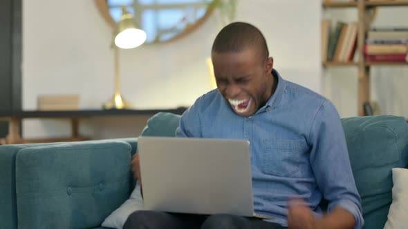 Angry Young African Man Feeling Disappointed on Laptop 