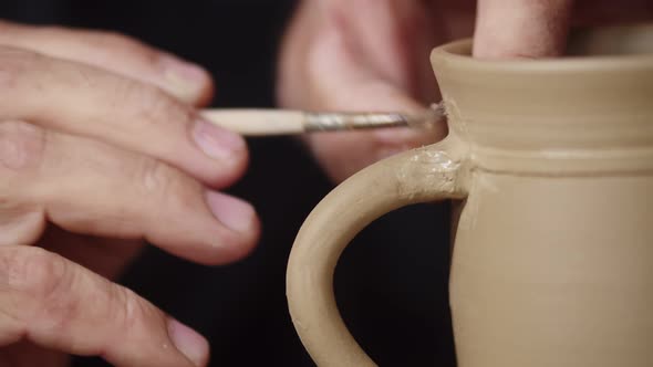 Potter Uses Brush While Processing Ceramics in Workshop Closeup