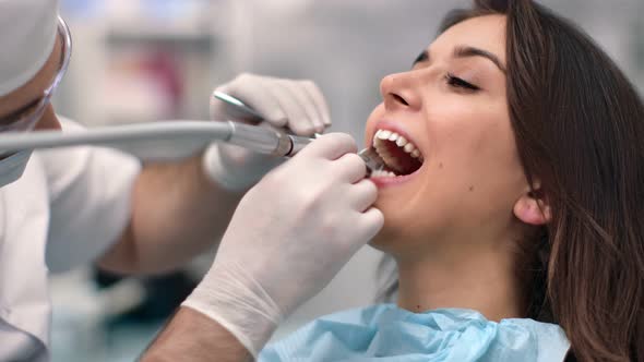 Close Up Female Patient with Open Mouth During Tooth Treatment