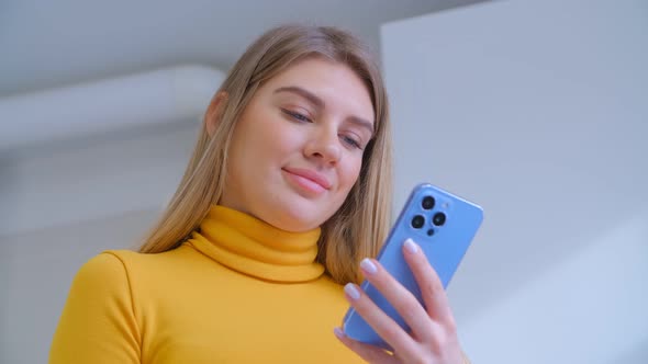 Beautiful white female using modern smartphone gadget with cheerful smile in 4k footage