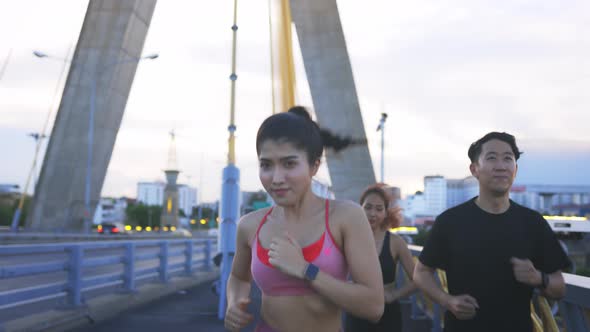 Young Man and Woman Friends Running at Bridge