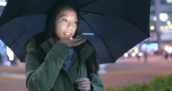 Woman using smart phone in the city at rainy day