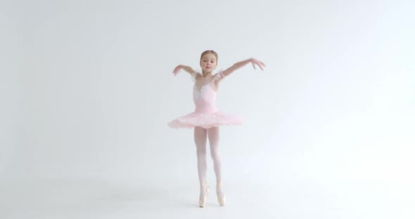 Elegant Little Girl in a White Tutu, Dance Ballet and Perform Choreographic Elements on a White