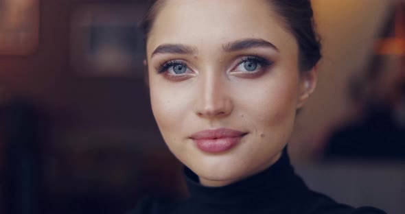 Portrait of Young Female in Black Shirt Posing Sensually and Looking at Camera