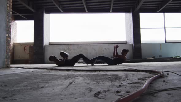 African american man and woman exercising with medicine ball in an empty urban building