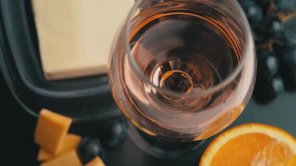 A Glass of Ros Wine Swirls With Appetizers