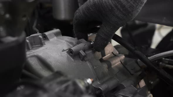 Mechanics in a Car Workshop Disassemble the Gearbox in the Engine of a Tricycle