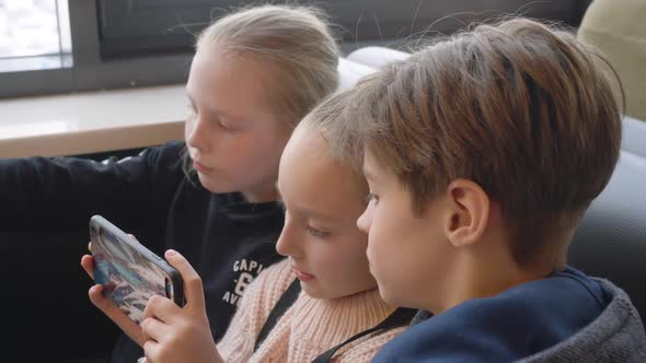 Teenager Teams Looking Mobile Phone at Table in Fast Food Cafe