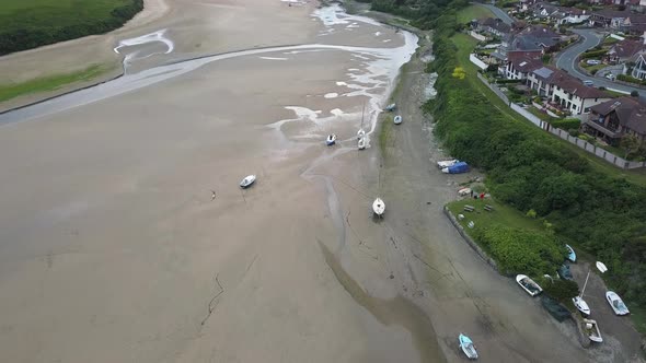 Boats On River Gannel During Low Tide With Pentire Village In Cornwall, England, United Kingdom. - a