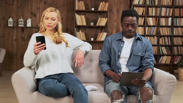 Bored Mixed Ethnicity Couple Ignoring Each Other