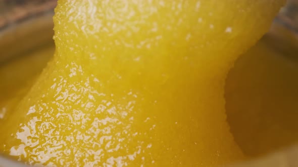 Crystalline Honey in a Jar, Macro, The Spoon is Dipped in thick Honey