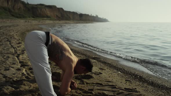 Strong Man Bending Back Stretching on Beach