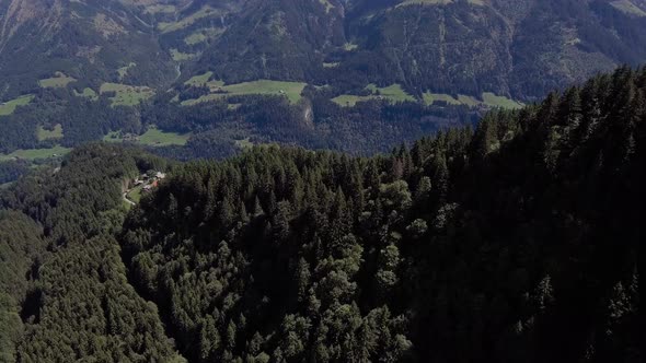 Flight over fir trees and cottages in front of the Dents du midi