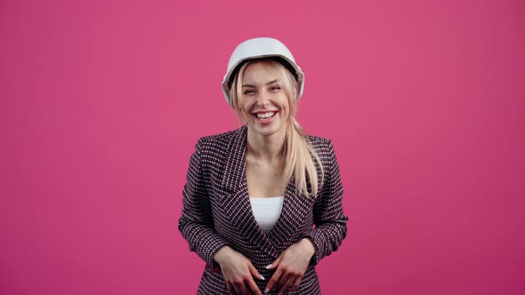 Happy Young Woman Wearing an Engineer's Helmet Smiling at the Camera Young Mature Blonde in Pink