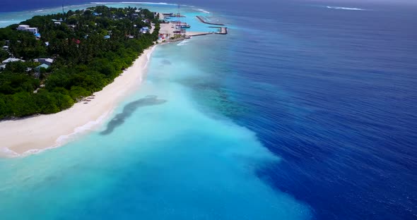 Wide angle fly over travel shot of a sunshine white sandy paradise beach and aqua turquoise water 