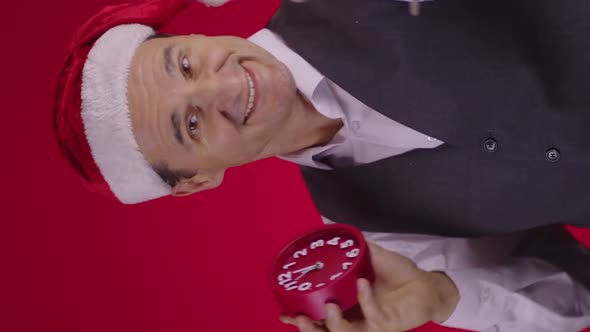 Vertical Shot Cheerful Man in Santa Hat Holds Clock Drinking Champagne Seconds Before New Year