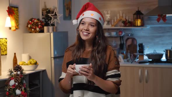 Smiling Woman with Santa Hat in Festive Kitchen