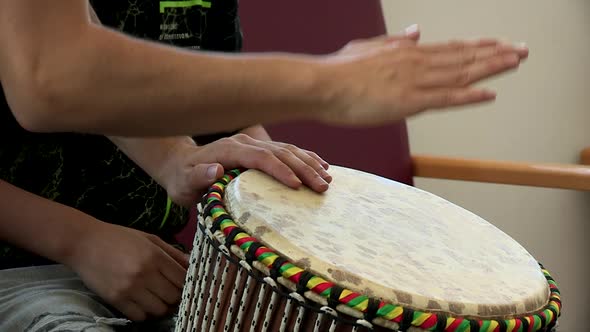 close-up of teacher and student hands playing djembe. African percussion instrument.
