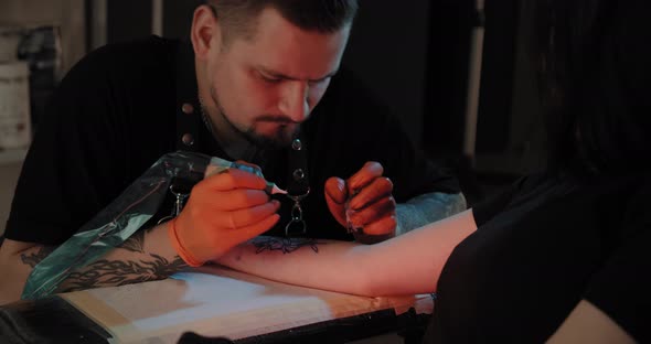 Portret Tattoo Artist Draws a Picture on the Hand, the Process of Creating a Tattoo. Slow Motion.