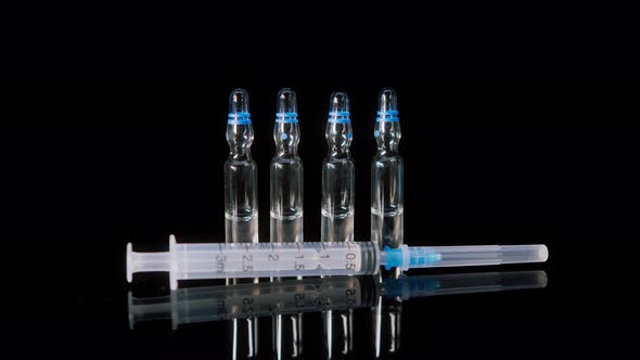 Closeup of Syringe and Ampoules with Vaccine Against Coronavirus