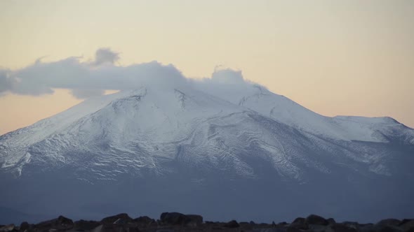 Time lapse of low clouds moving over snow-capped mountains in the Atacama Desert