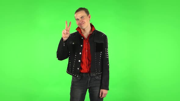 Guy Shows Two Fingers Victory Gesture. Green Screen