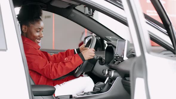 African American Woman Choosing a Car in a Salon and Checking the Salon