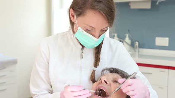 Young female dentist doing checkup for elderly female patient